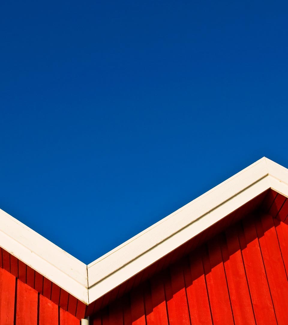 Deep blue sky above bright red beach huts
